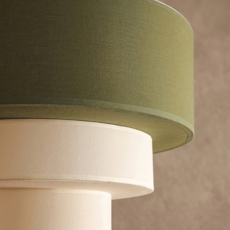Modern layered fabric pendant light in green and white with soft diffused glow for contemporary interiors.