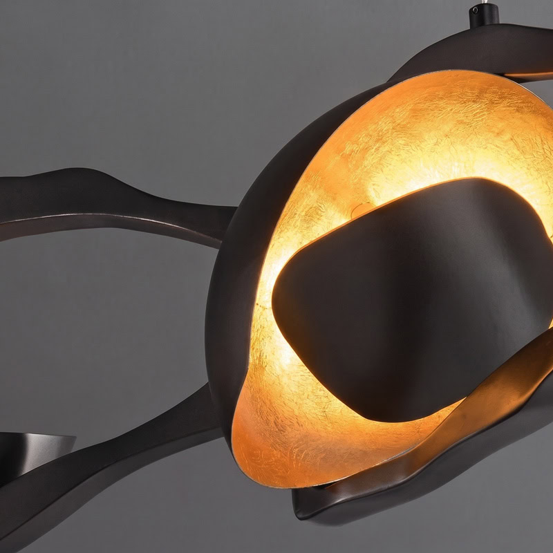 Black Designer Sculptural Pendant Light NOVARA LG363 with flowing curvilinear metal rings in a black and gold finish above an interior setting